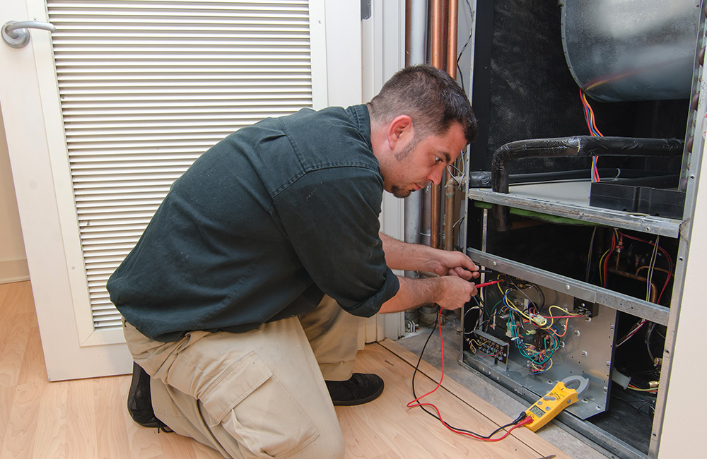 Reckingers Heating & Cooling hvac tech repairing a heating system